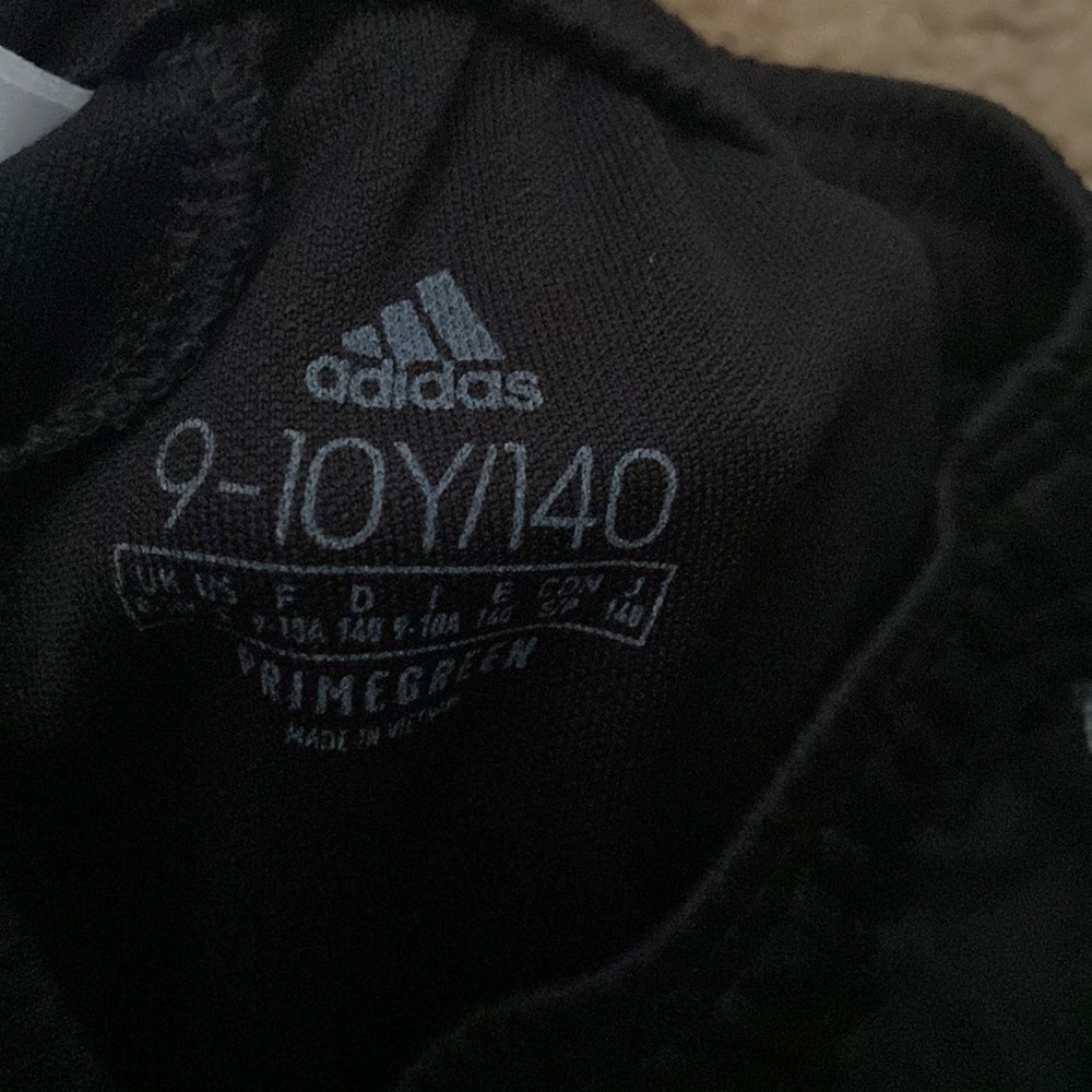 Classic black adidas pants with white stripes that have mesh on them